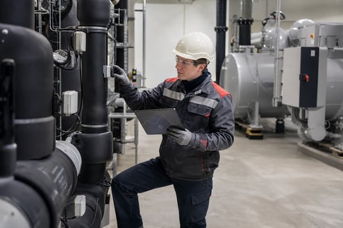 Industrial Facility Technician Inspecting Pipes